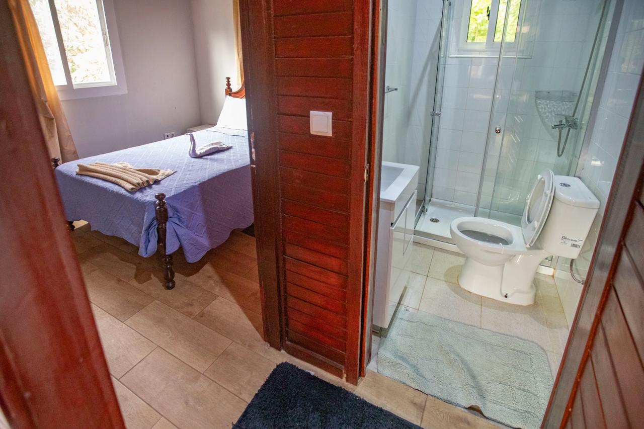 Quarto com cama e casa de banho privativa com duche